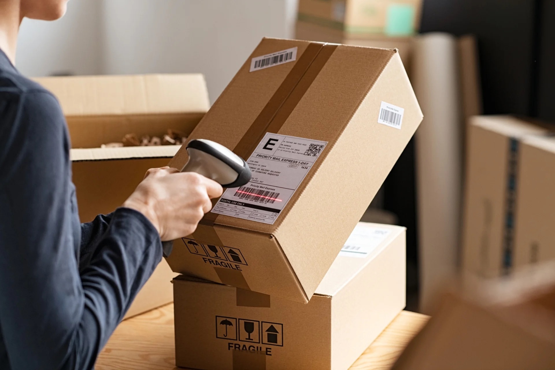 Delivery driver smiling at the camera while leaning on boxes in front of van